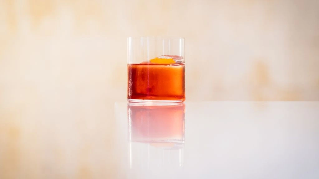 Overhead view of a Negroni cocktail with orange peel on a linen napkin