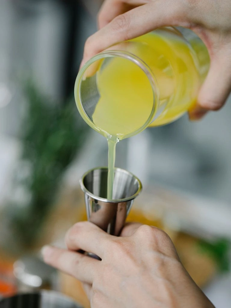 A bartender nosing a crystal tasting glass of amber whiskey under warm editorial light.
